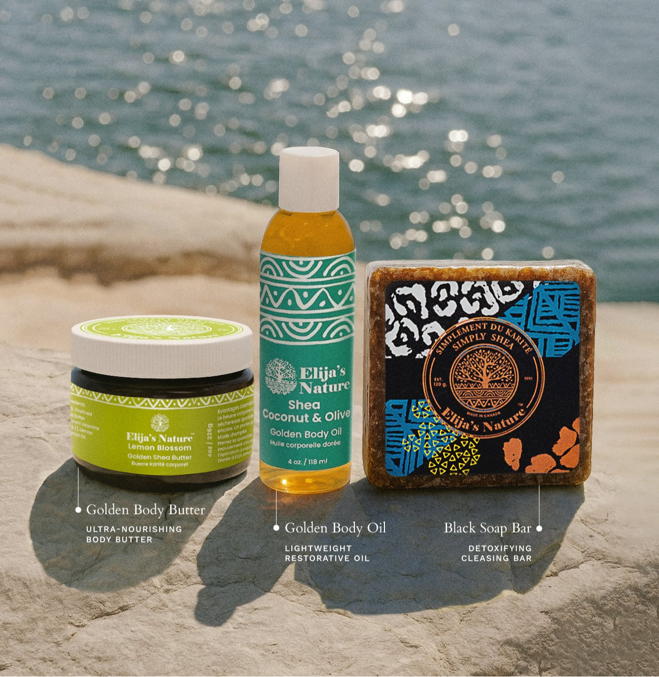 The three products from the Morning Glory Gift Set in Olive Coconut displayed on a sunlit stone surface by the water with visible product information
