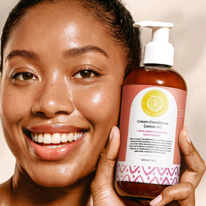 Cream Conditioner Leave-In - #size_8oz Cream Conditioner Leave-In - Smiling woman holding a 8oz bottle of Elija’s Nature Cream Conditioner (Leave-In) near her face