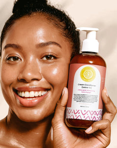 Cream Conditioner Leave-In - #size_8oz Cream Conditioner Leave-In - Smiling woman holding a 8oz bottle of Elija’s Nature Cream Conditioner (Leave-In) near her face