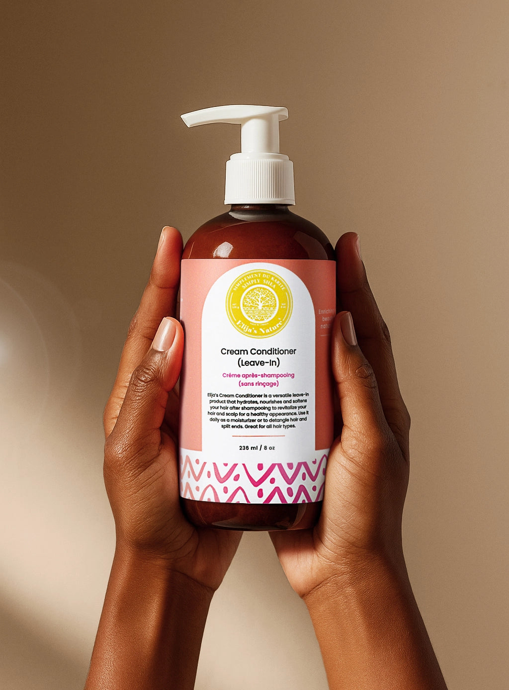 Cream Conditioner Leave-In - #size_8oz - Hands holding a bottle of Elija’s Nature Cream Leave-In Conditioner upright against a neutral background
