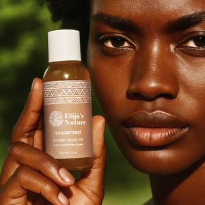 Golden Body Oil - #scent_Unscented #size_2oz - Woman holding an Unscented bottle of Elija’s Nature Golden Body Oil 2oz near her face