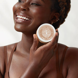 Golden BodyButter - #scent_Unscented #size_8oz - Smiling woman holding an Unscented jar of Elija’s Nature Golden Body Butter 8oz near her face